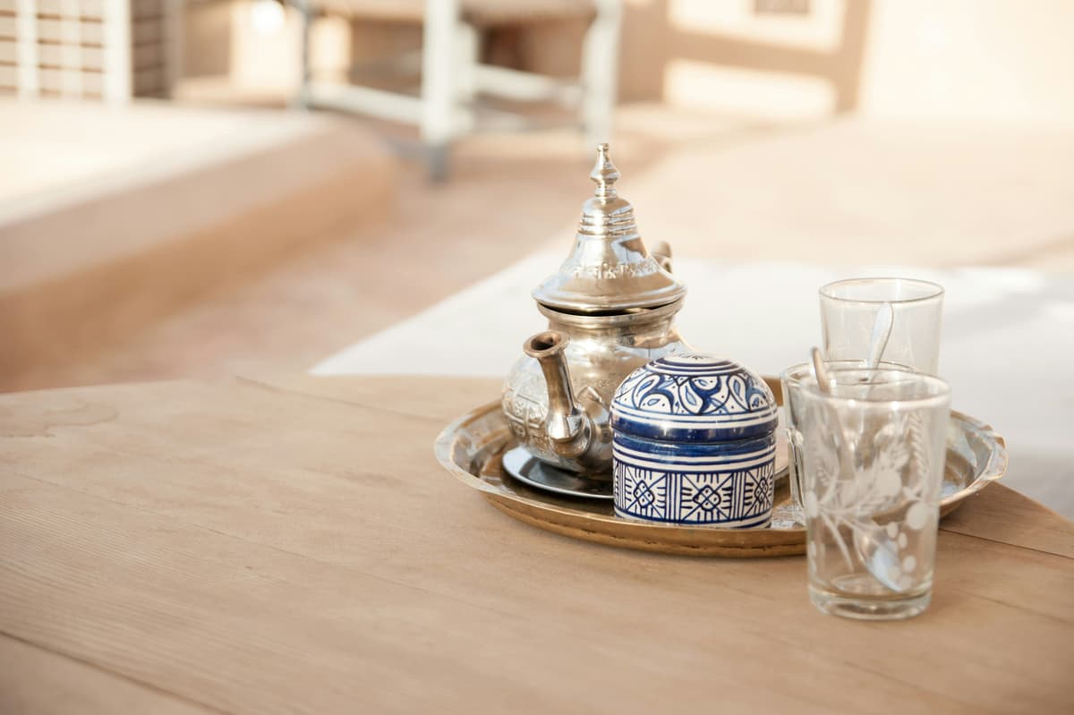 traditional Moroccan mint tea poured from a silver teapot into decorated tea glasses