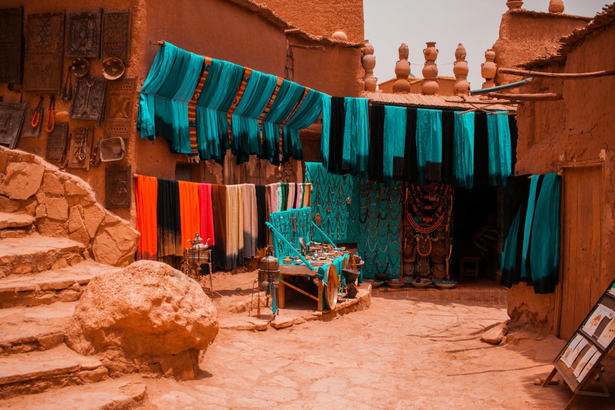 Moroccan traditional clothing including babouches and Amazigh-inspired textiles in a Marrakech souk
