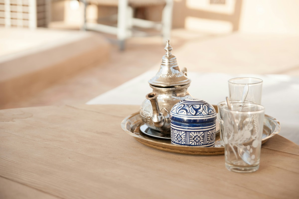traditional Moroccan mint tea poured from a silver teapot into decorated tea glasses