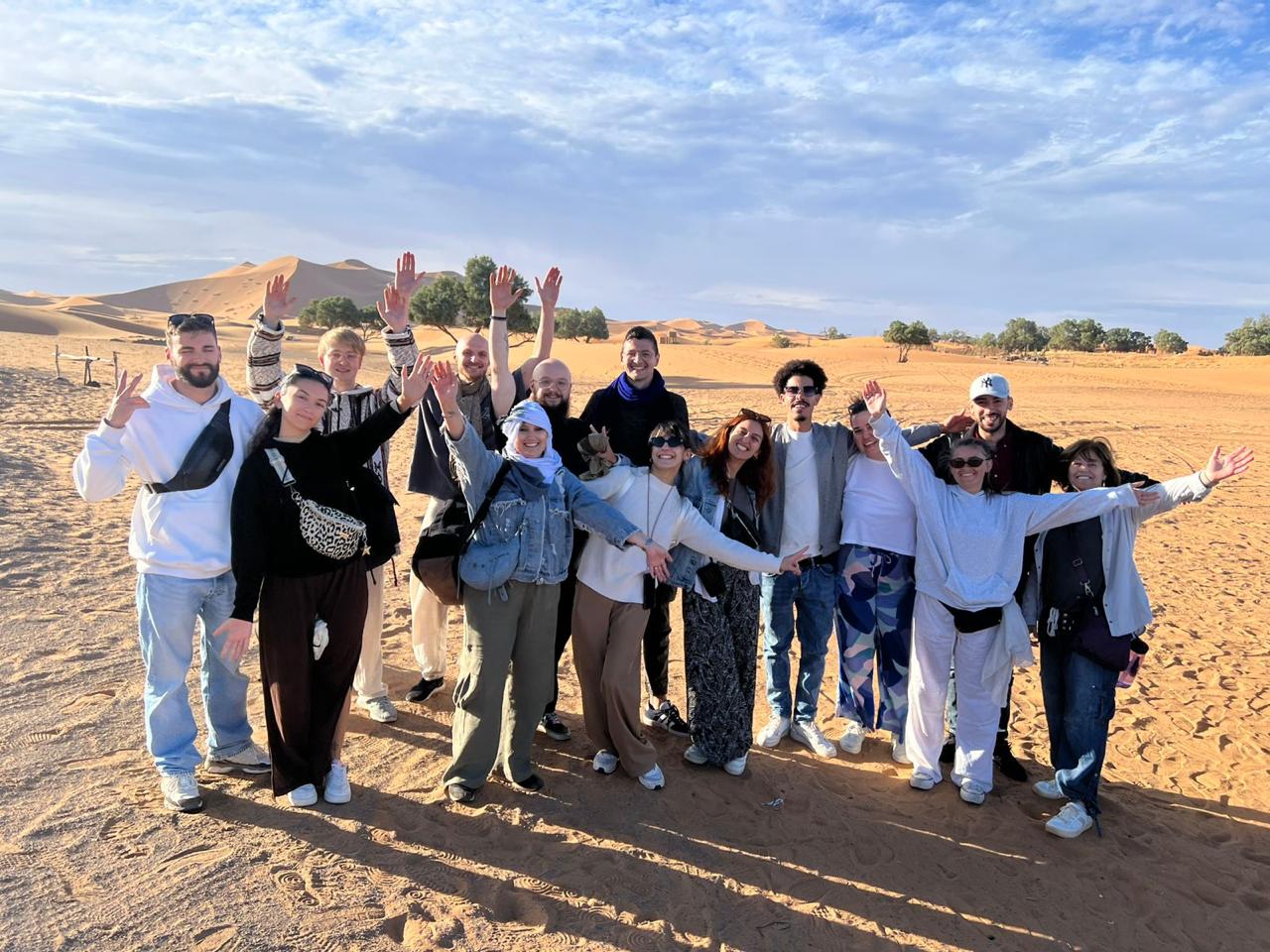 Our local Berber guides with happy travelers in the Sahara desert