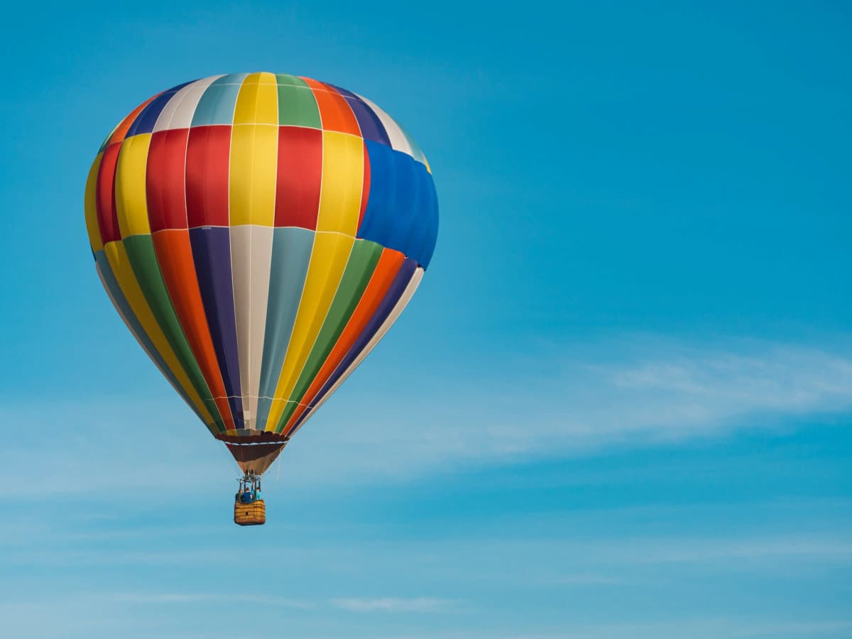 Hot air balloon flying over Marrakech countryside at sunrise