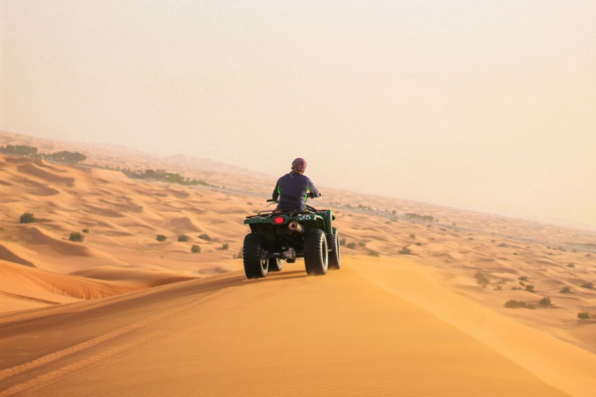 Quad bike riding across the golden dunes of Erg Chebbi near Merzouga, Morocco
